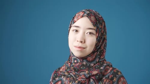 Unschuldige und schöne muslimische asiatische Frau im Hijab lächelt.