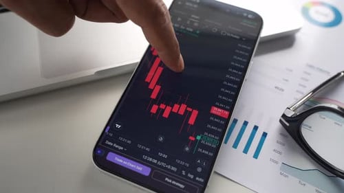 Stock Exchange Broker Analyzing Real-Time Stocks and Exchange Market Charts on Smartphone Using