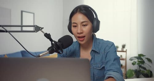 Woman Talking into Microphone Using Laptop at Home