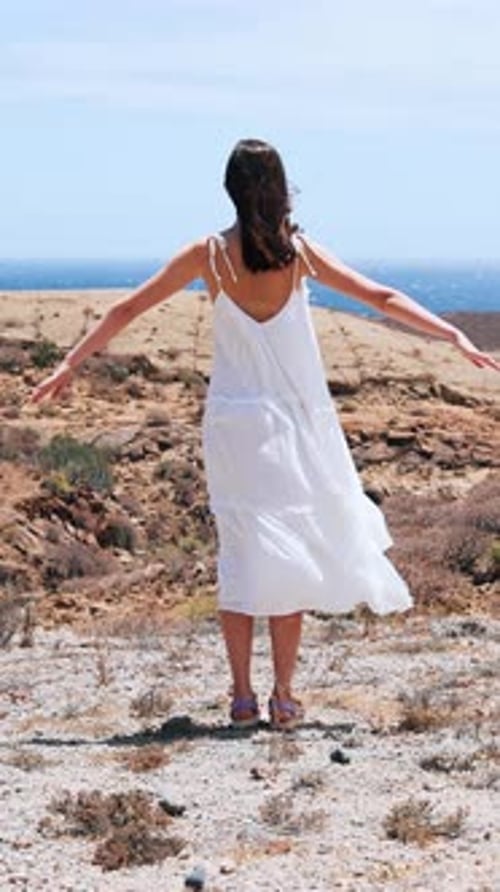 A Woman in White Gazes at the Ocean Feeling Freedom and Serenity