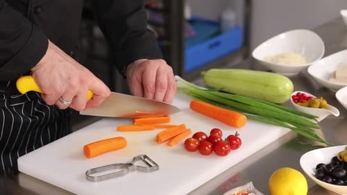 Chef Slicing Carrots in Commercial Kitchen