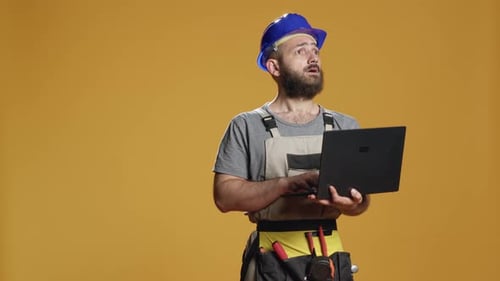 Portrait of Handyman Using Laptop to Find Construction Inspiration