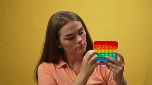Woman Plays with Rainbow Pop It Fidget Toy
