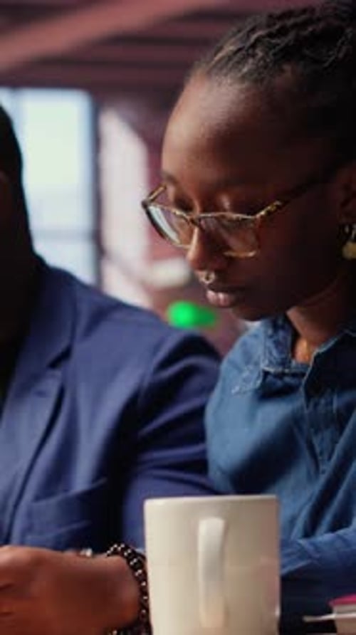 Worried African American Woman Looks at Tax Numbers on Documents