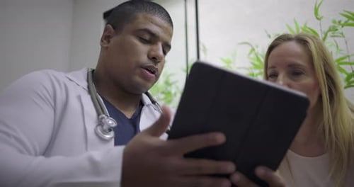 Healthcare Professional Consults with Patient Using Tablet