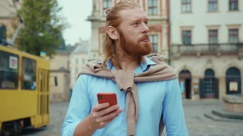 Bearded Hipster Casual Businessman Using Smartphone Walking in Beautiful City Center Appealing