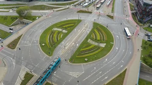 Aerial drone shot over Grunwaldzkie roundabout with car movement in Krakow, Poland at daytime.