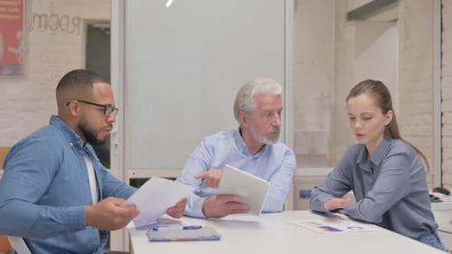 Business People Discussing Project on Digital Tablet in Office