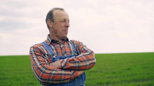 Farmer Smiling in Green Field on Overcast Day