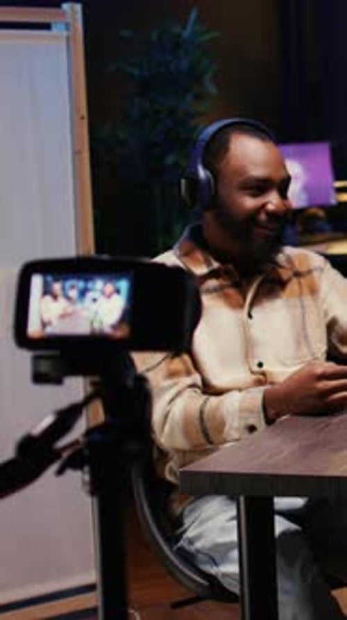 Man Vlogging in Dimly Lit Home Studio