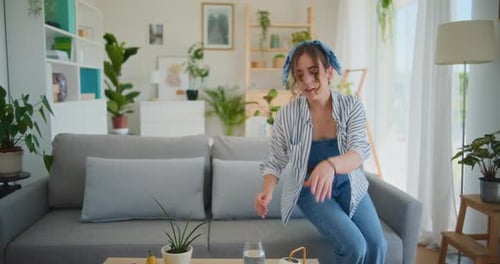 Woman Relaxing and Watering Plants at Home