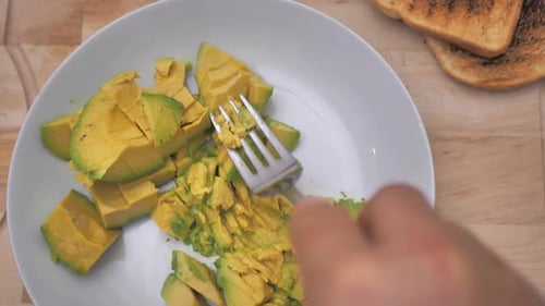 Avocado Being Mashed on Plate for Toast