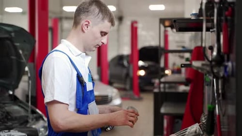 Un mecánico de automóviles ensambla el motor con precisión en el taller, un técnico instala anillos de pistones en