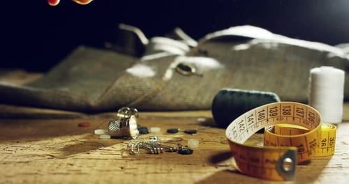 Slow motion sew of a hand of a young tailor who sew with a needle and thread by hand according to