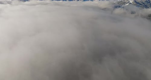 Tilt Shot Of Snowy Mountain Range And Clouds Under Blue Skies