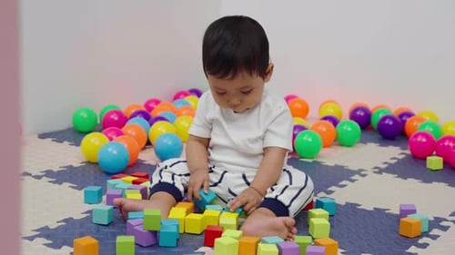 Adorable Baby Playing with Colorful Blocks and Balls