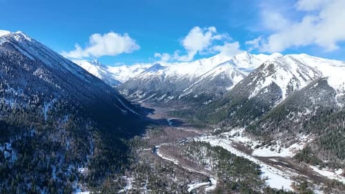 Aerial panorama of Caucasus valley with snow and pine forest