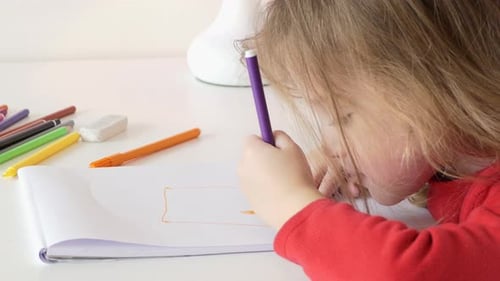 Child Drawing With Markers at Table