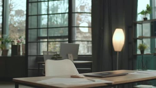 Close Up View on Desk with a Laptop in Empty Office Workspace Camera Moving Around 360 Degrees
