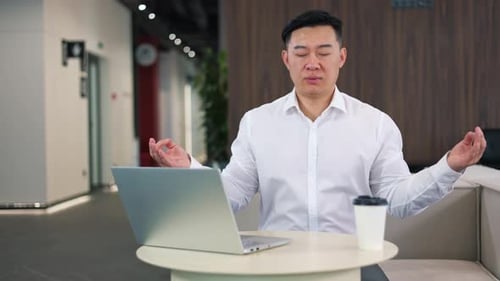 Man Meditating at Table in Office Setting