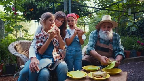 Family enjoying a meal together in their vegetable garden