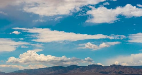 Verträumte Wolken bilden sich und wehen im Wind über den Wüstenbergen - Zeitraffer