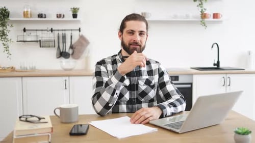 Young Man Working at Home in Kitchen
