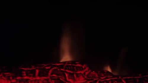 Cheminée chaleureuse et allumée - un feu rougeoyant dans la cheminée en pierre pour se réchauffer la nuit. Plan rapproché.