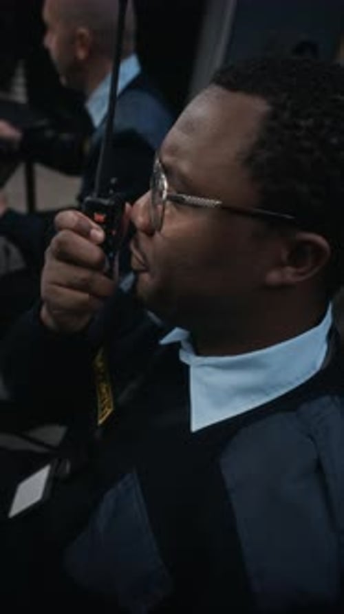 Security Guard Speaking into Walkie-Talkie in Control Room