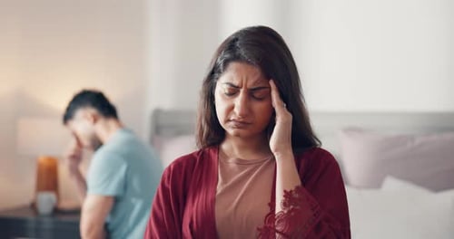 Woman Suffering from a Headache with Man in Background