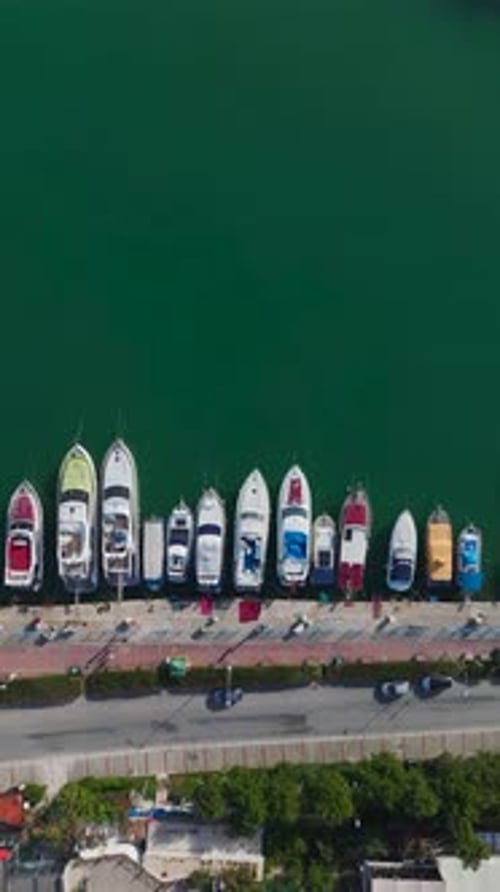 Vidéo verticale d'une magnifique marina touristique capturée par un Drone avec des bateaux se balançant doucement sur le