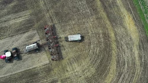 Combine harvester on the move in sunny agricultural field drone point of view