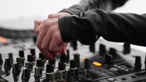 Femme DJ professionnelle jouant de la musique électronique contemporaine dans une boîte de nuit, gros plan des mains sur une table de mixage