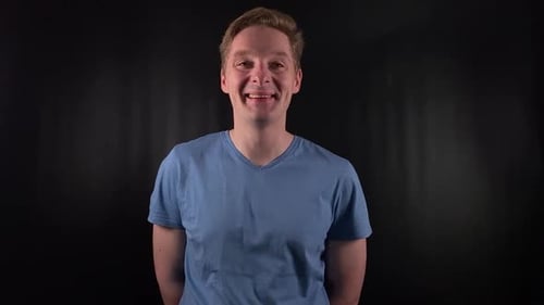 Man Smiling and Laughing in Front of Black