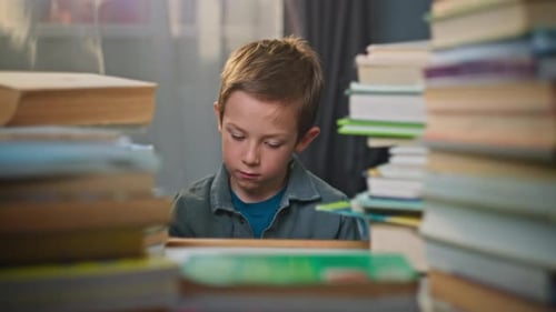 Attentive Boy Reads Book Surrounded by Stacks