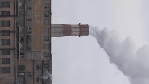 Red and White Factory Chimney Smoking Dense White Smoke Above City