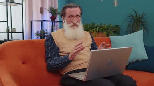 Senior Man Video Calling on Laptop Indoors