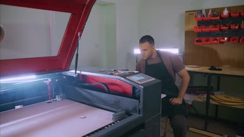 Techniker bedient Lasergravurmaschine in der Werkstatt
