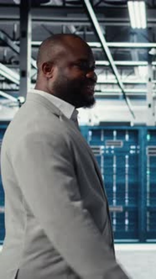 Vertical Video Engineer Walking in Data Center Facility Doing Inspection on Hardware Tech