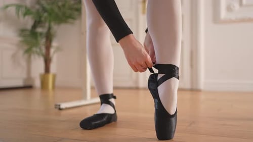 Ballerina Puts on Pointe Shoes on Leg in Dance Class Classical Ballet Dancer Woman in Dance Studio