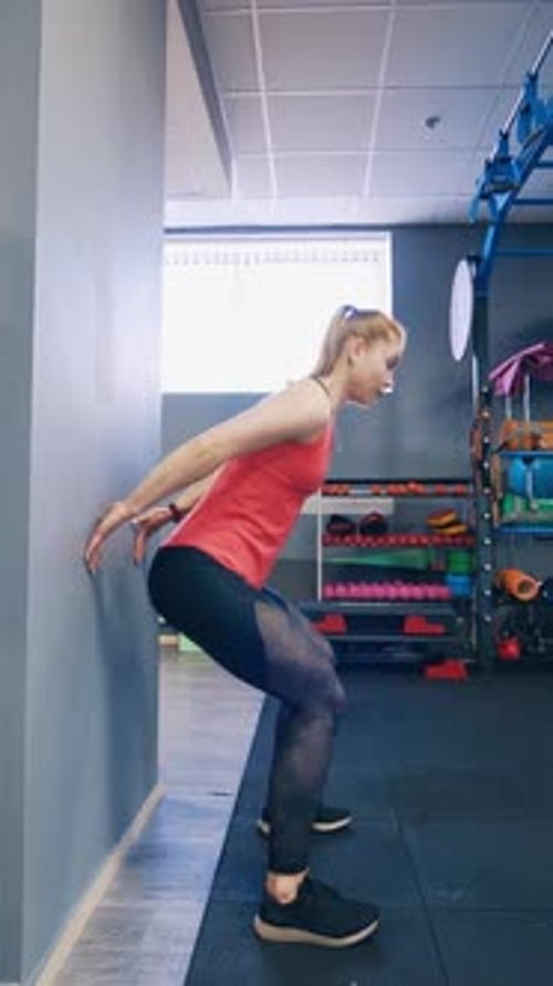 Woman Doing Wall Sit Exercise at the Gym
