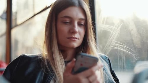 Uma jovem profundamente envolvida em usar seu telefone celular em um ambiente aconchegante e convidativo