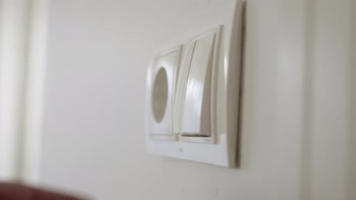 Mão do homem apaga a luz no quarto