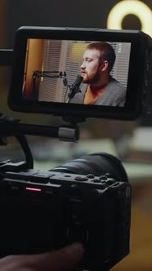 Vertical of Operator Adjusting Camera while Recording Podcast in Studio