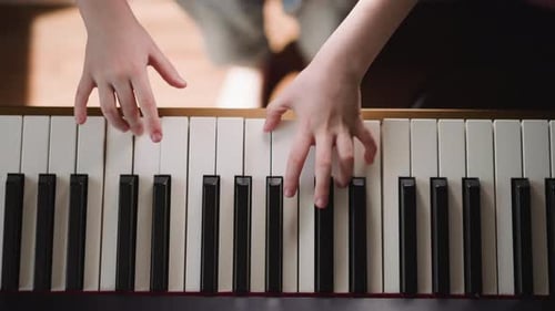 Child Plays Piano in a Close Up Shot