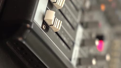 Professionelles Audiomischpult mit Fadern und Einstellknöpfen, TV-Ausrüstung. Vertikaler Schuss