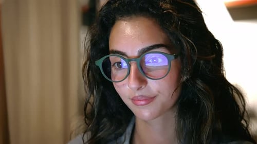 Portrait of Young Woman at Home Looking at Laptop and Working on Computer Screen