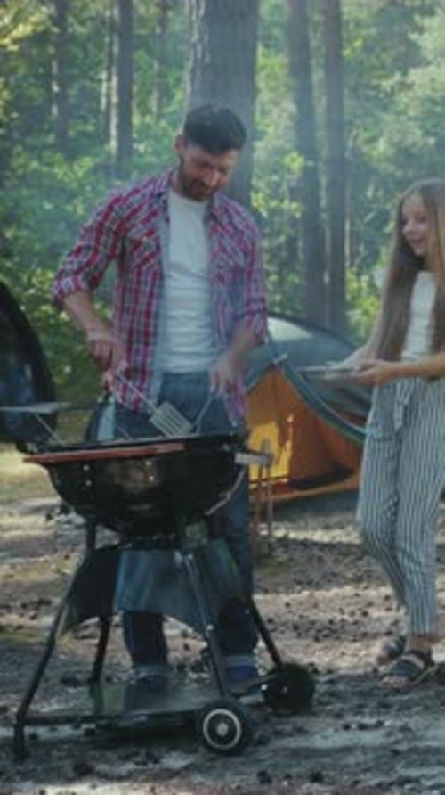 Dad and Daughter Barbecuing Together While Camping