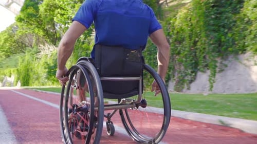 Man Exercising in Wheelchair on Outdoor Urban Trail