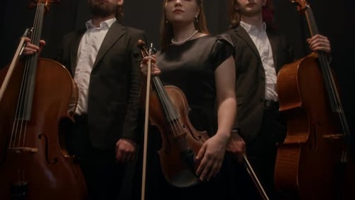 Portrait of Violinist with Cellists on Black Background